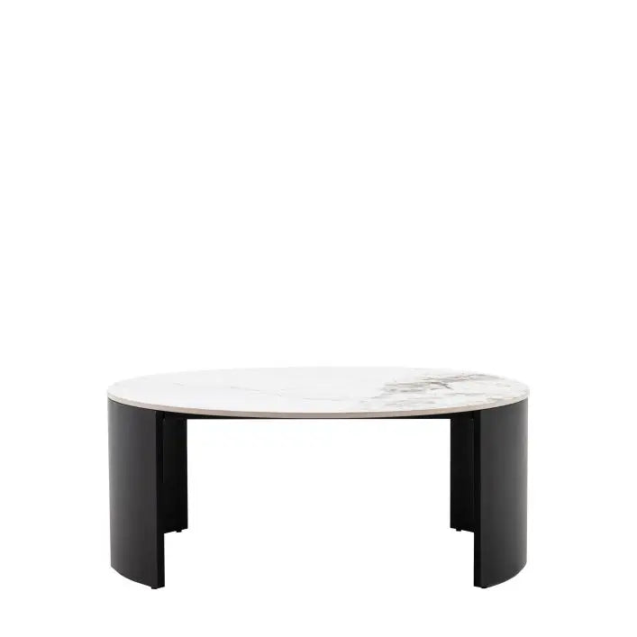 The Gallery Direct Marzio Round Coffee Table features a Carrara marble-style stone table top and gently curved, black metal legs for a contemporary design
