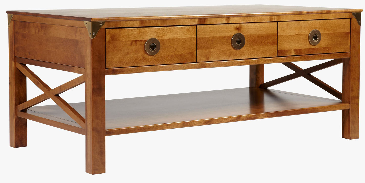 Laura Ashley Balmoral 3 Drawer Coffee Table in Honey birch wood features 3 top storage drawers with brass handles, underneath shelf space with cross-frame side detailing, and brass corner brackets