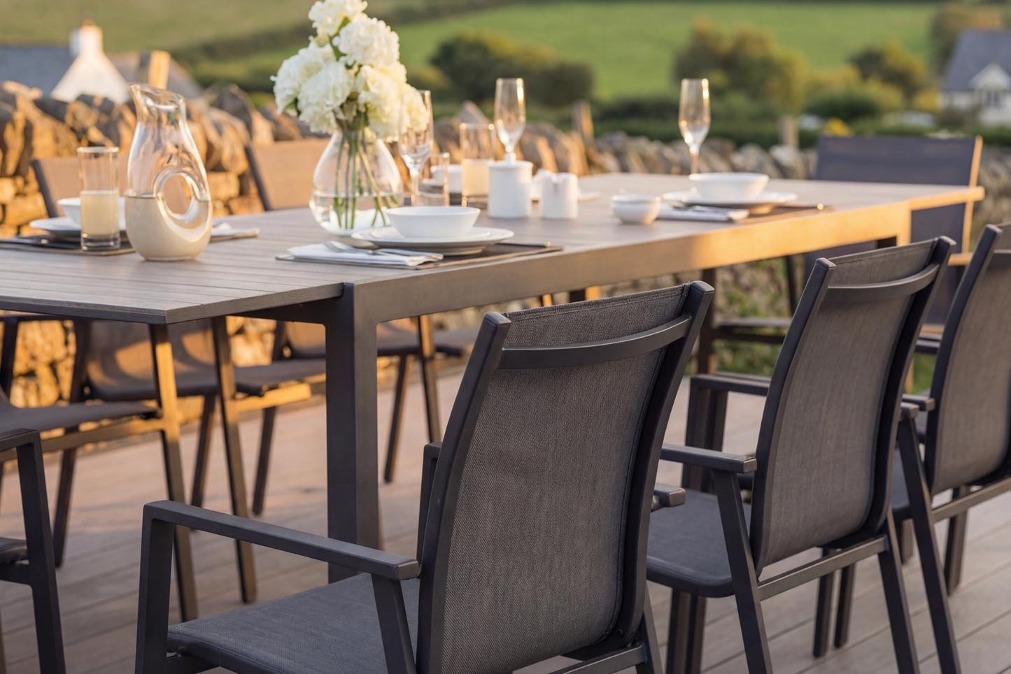 The Royal Garden Catala 8 Seater Extending Dining Set features a generous extending table with wood-effect table top, plus 8 aluminium stacking chairs with textilene fabric seats in a charcoal grey finish