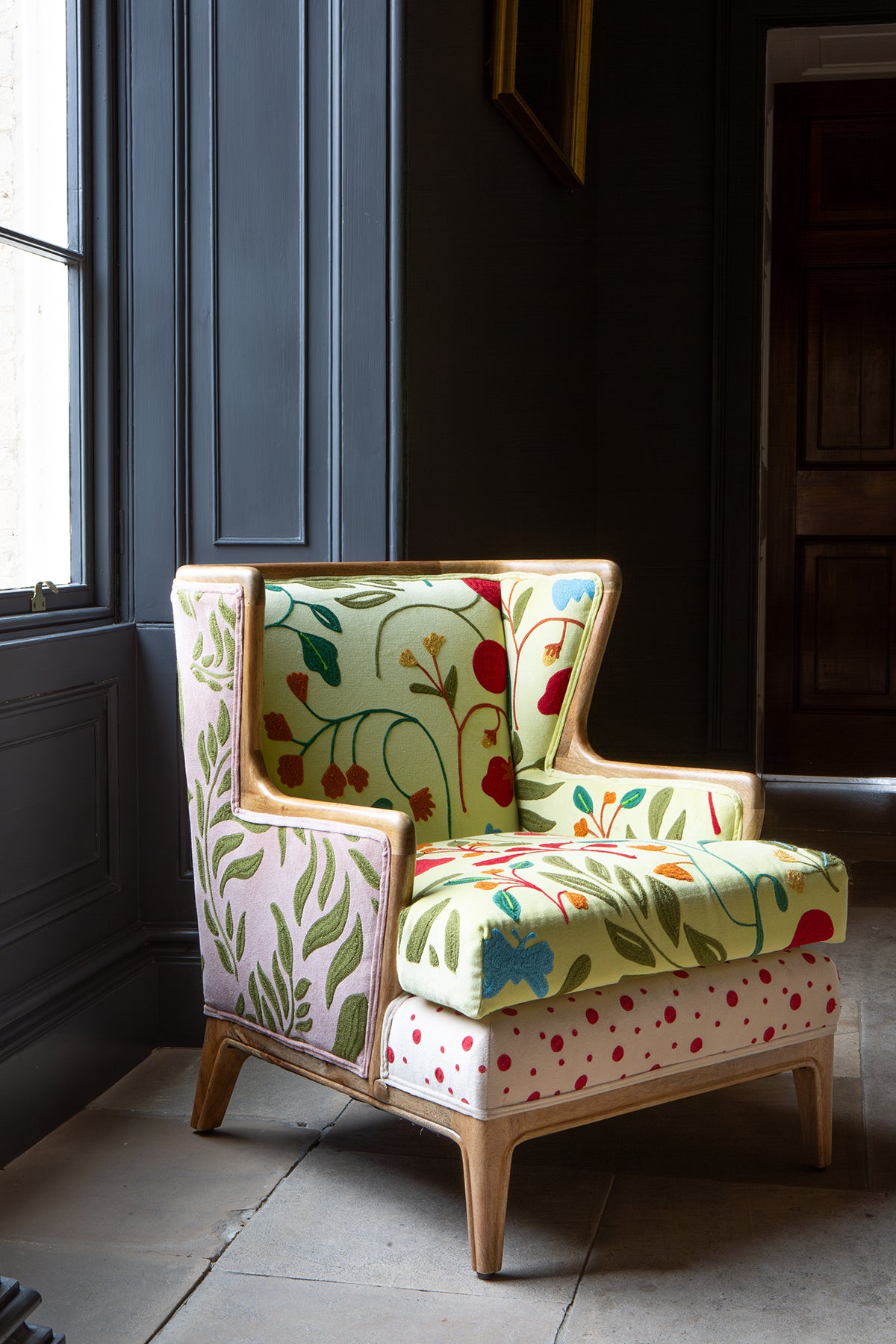 Colour and pattern do the hard work here, with Botanical prints, embroidered detailing, leaf motifs and red polka dots, brought together in a compact wingback shape with a natural wood frame