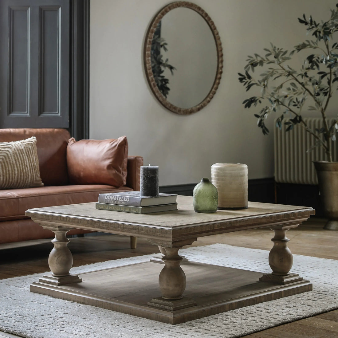 Rustic wooden coffee table styled with candles and books in a living room