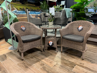4 Seasons Outdoor Chester Penida Bistro Set in Pure Weave material has a glass top bistro table with lower shelf and 2 armchairs with seat pads