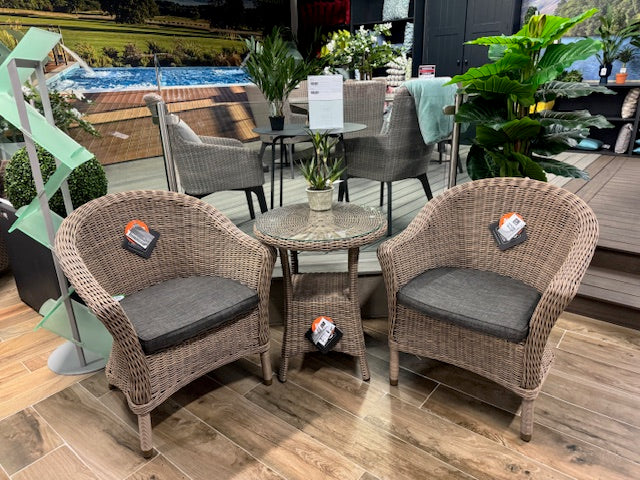 4 Seasons Outdoor Chester Penida Bistro Set in Pure Weave features 2 rattan armchairs with grey seat pads and a glass top bistro table