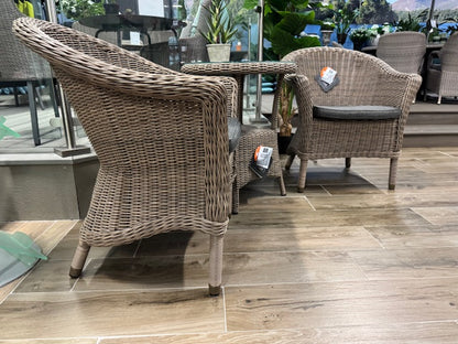4 Seasons Outdoor Chester Penida Bistro Set in Pure Weave features 2 armchairs with seat pad cushions and a glass top bistro table with lower shelf
