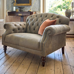 Tetrad Arbroath Snuggler Sofa in Commanche Timber Leather Hide, with deep button tufting to the classic chesterfield inspired design, scrolled arms with stud detailing and dark wooden legs