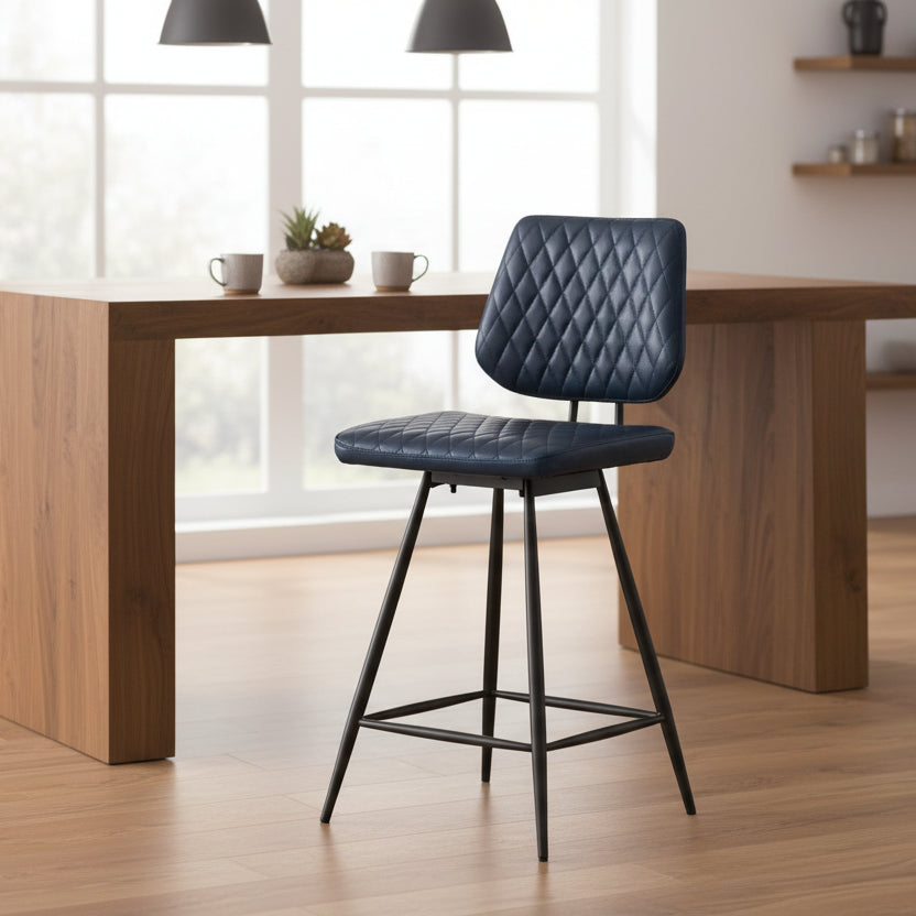 Baker Dalton Bar Chair in a Dark Blue diamond stitch faux leather upholstery, has a 180 degree swivel seat and black metal legs with a footrest bar 