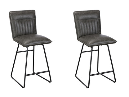 The Baker Cooper pair of Bar Chairs are upholstered in a distressed Grey faux leather material with a car seat inspired stitched design, and black metal tubular legs