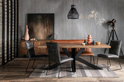 The Baker Pair of Cooper Dining Chairs are upholstered in a mottled Grey faux leather with car seat inspired stitched design and black metal tubular legs