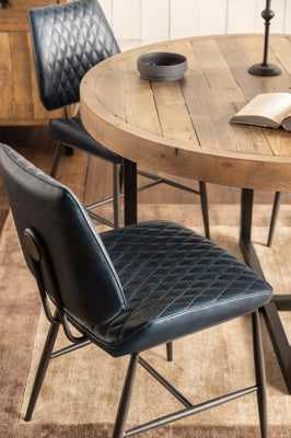 The Baker Pair of Dark Blue Dalton Dining Chairs feature a diamond quilted design to the faux leather fabric, and black powder coated metal legs and frame