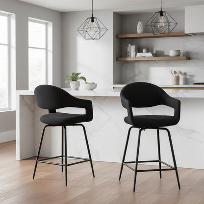 The Baker Pair of Jasmine Bar Chairs in Black Boucle fabric with cut out backrest and 180 degree swivel function, and black metal legs with footrest bar