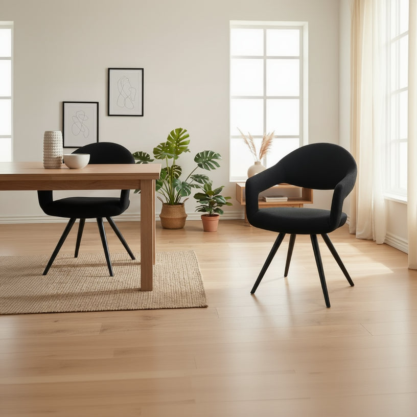 Baker Pair of Jasmine Dining Chairs are upholstered in a Black Boucle effect fabric, featuring a contemporary cut out back rest design and black powder coated aluminium legs