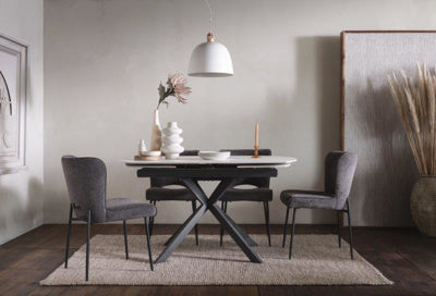 The Baker Pair of Maya Dining Chairs are upholstered in a Dark Grey linen fabric with faux leather piping detail and black powder coated metal legs