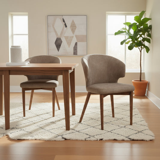 The Baker Pair of Rowan Dining Chairs are upholstered in a light brown PU leather fabric and walnut brown finish legs