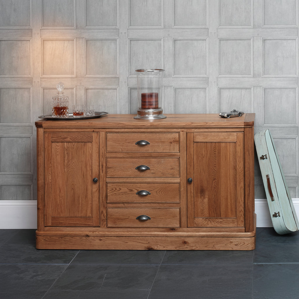 Carlton Furniture Copeland Large Sideboard is crafted from solid natural oak and features 4 central drawers with metal cup handles, and 2 side cupboards with metal door knobs