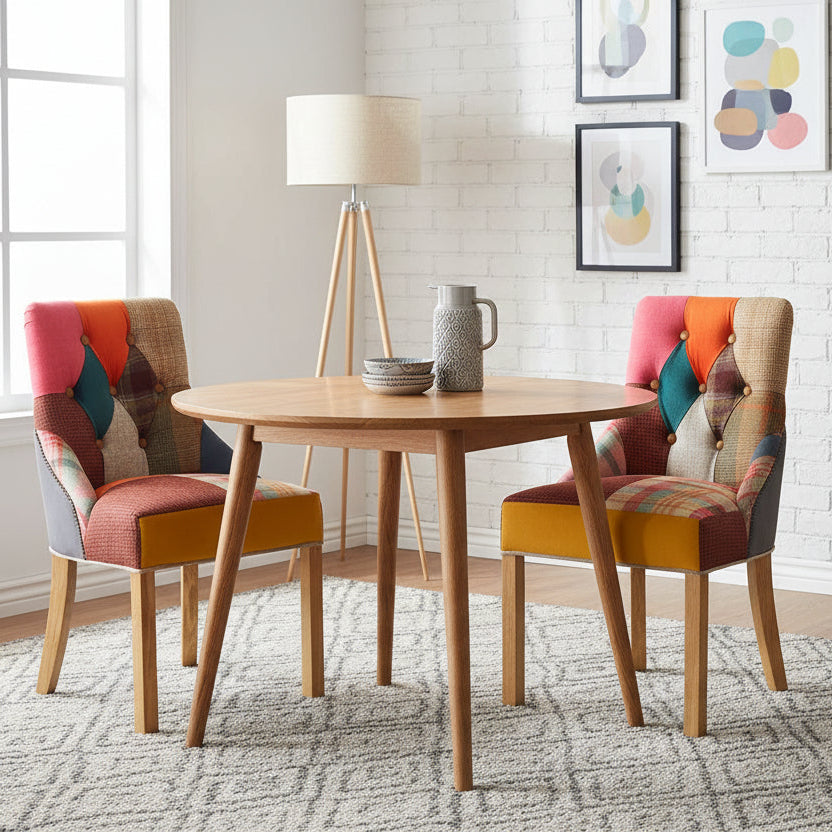 The Carlton Furniture Pair of Stanton Chairs are upholstery in a colourful array of Patchwork fabrics, with button tufting to the backrest, stud detailing at the back of the chairs, and natural wooden legs