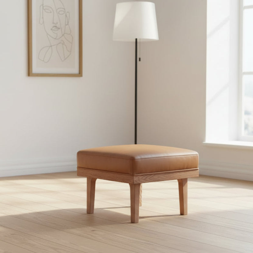 Carlton Furniture Wilton Relax Stool features a wooden base with a tan leather cushioned top 