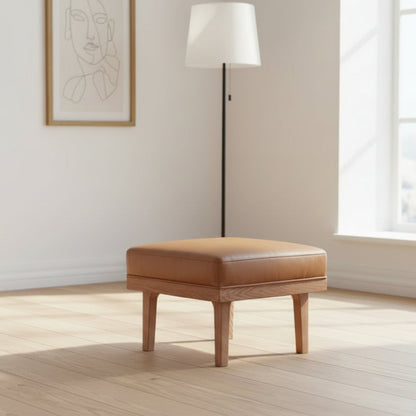 Carlton Furniture Wilton Relax Stool features a wooden base with a tan leather cushioned top 