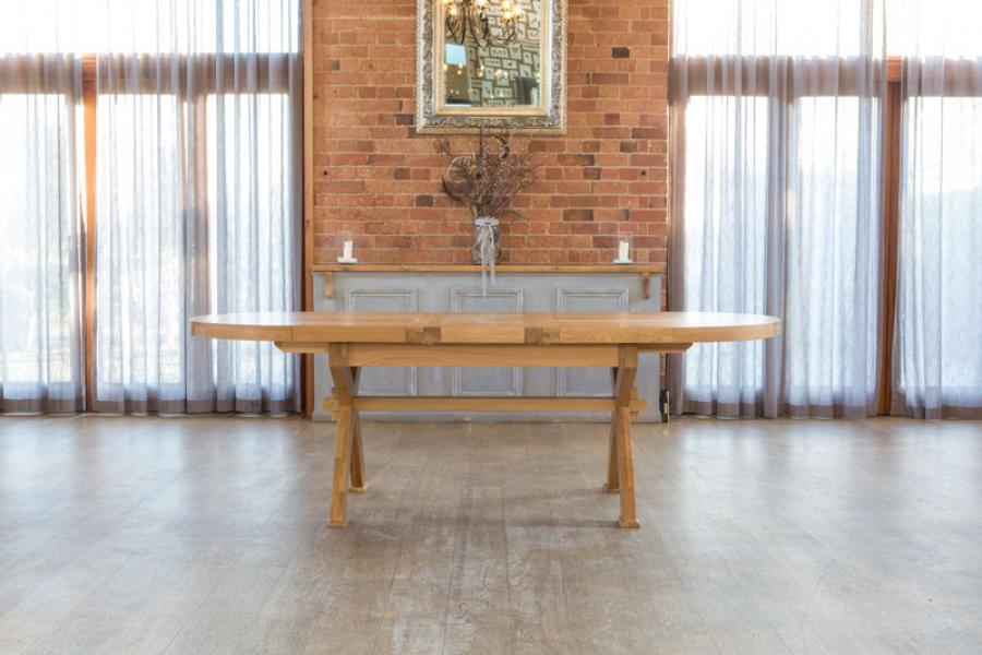 Carlton Furniture Windermere Oval Extending Dining Table made from solid natural oak, with cross leg base, can seat 8-12 when fully extended