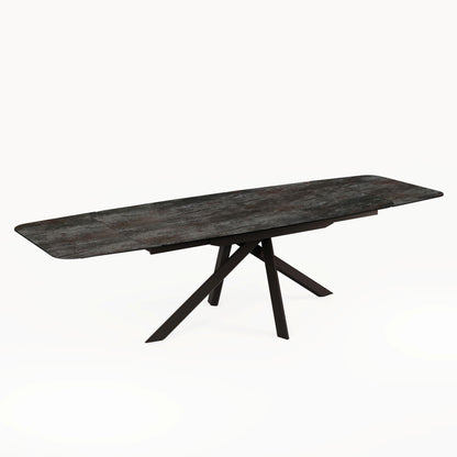 Angled studio view of the Florence Extending Oval Dining Table in Ceramic Volcano, showing its extended dark top and black base.