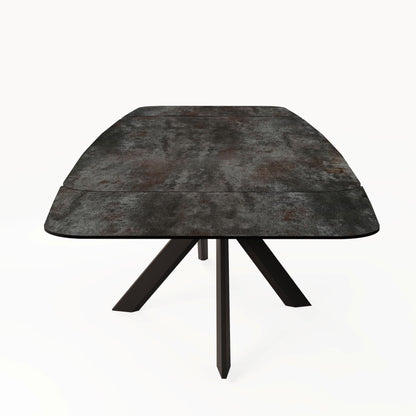 End-on studio view of the Florence Small Extending Dining Table in Ceramic Volcano, showing the patterned ceramic top and black base.