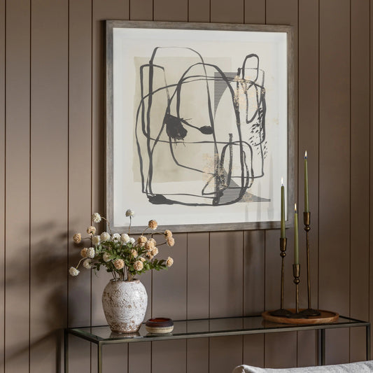 Gallery Direct Abstract Framed Art, styled above a console table against a warm brown panelled wall