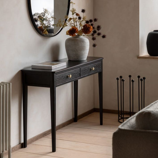 Gallery Direct Acton Black Console Table features 2 drawers with gold coloured handles, wood-grain effect and slim tapered legs