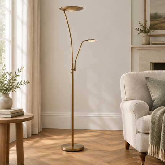 Gallery Direct Alassio Floor Lamp Antique Brass styled beside a linen armchair