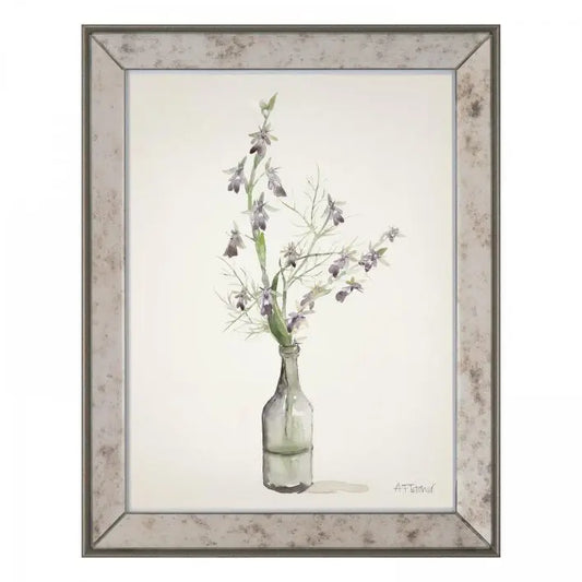 Gallery Direct Amethyst Orchids Framed Artwork by Adelene Fletcher depicts a glass bottle with wildflowers against a plain background, and framed in an antique effect bevelled mirror frame