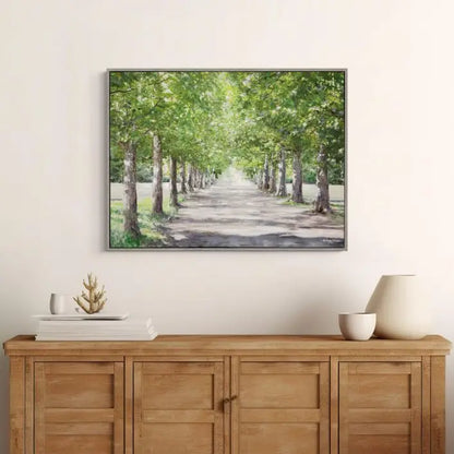 Gallery Direct Avenue of Trees Framed Canvas by Anthony Waller makes an ideal centrepiece with its warm sunny atmosphere through layers of foliage complemented by a grey wood effect frame