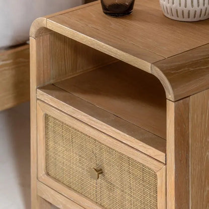 Gallery Direct Bibury 1 Drawer Bedside cabinet crafted from oak and pine wood and veneers with a soft lime washed finish. Rattan detail to the drawer front with a bronzed metal handle and an upper shelf for extra storage