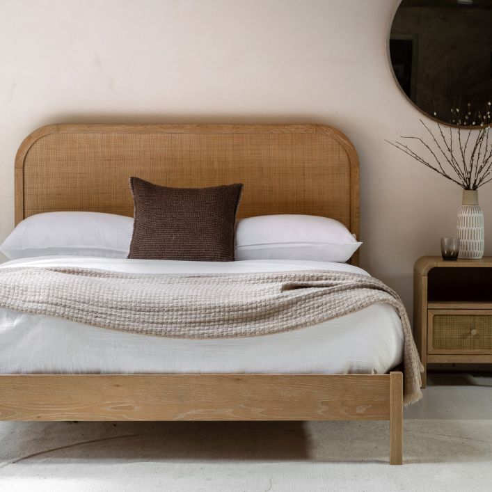 Gallery Direct Bibury Double Bed features a gently curved rattan headboard and a lime washed wooden frame