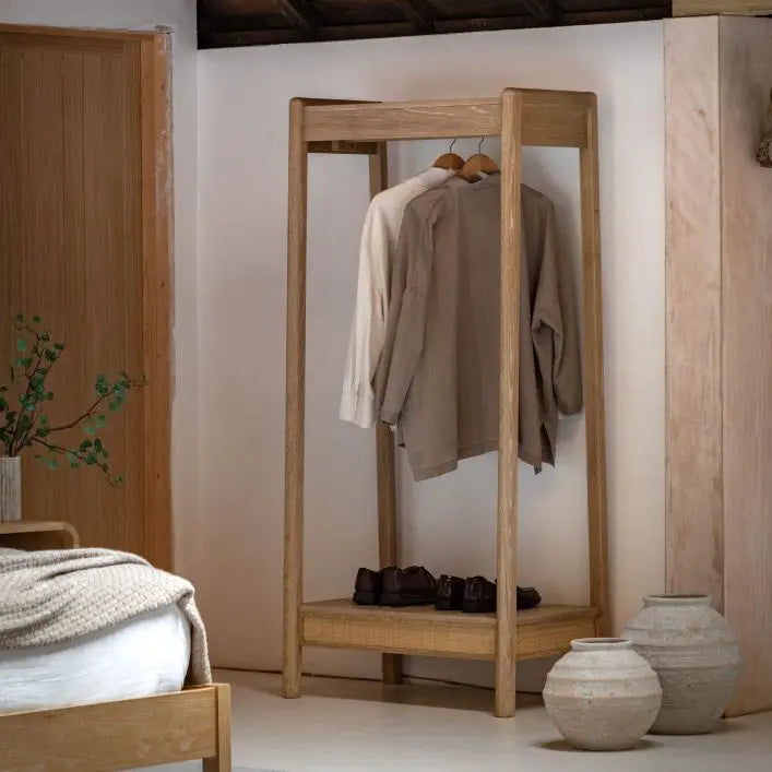 The Gallery Direct Bibury Open Wardrobe is crafted from oak and pine woods with a soft lime washed finish and rattan detailing to the lower shelf
