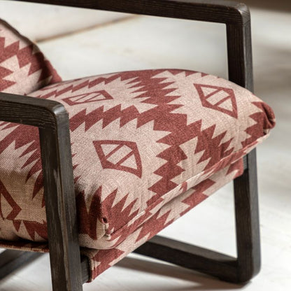 Gallery Direct Burela Lounge Chair in a padded red and natural coloured fabric with a Mira Aztec style design. The frame is made from a sturdy dark ash wood frame