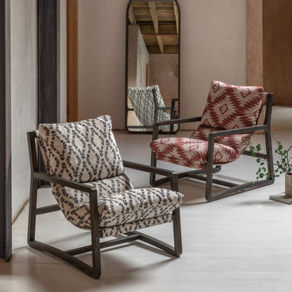 The Gallery Direct Burela Lounge Chair is upholstered in a navy and natural coloured Obi Diamond patterned fabric, with a rich dark wooden frame