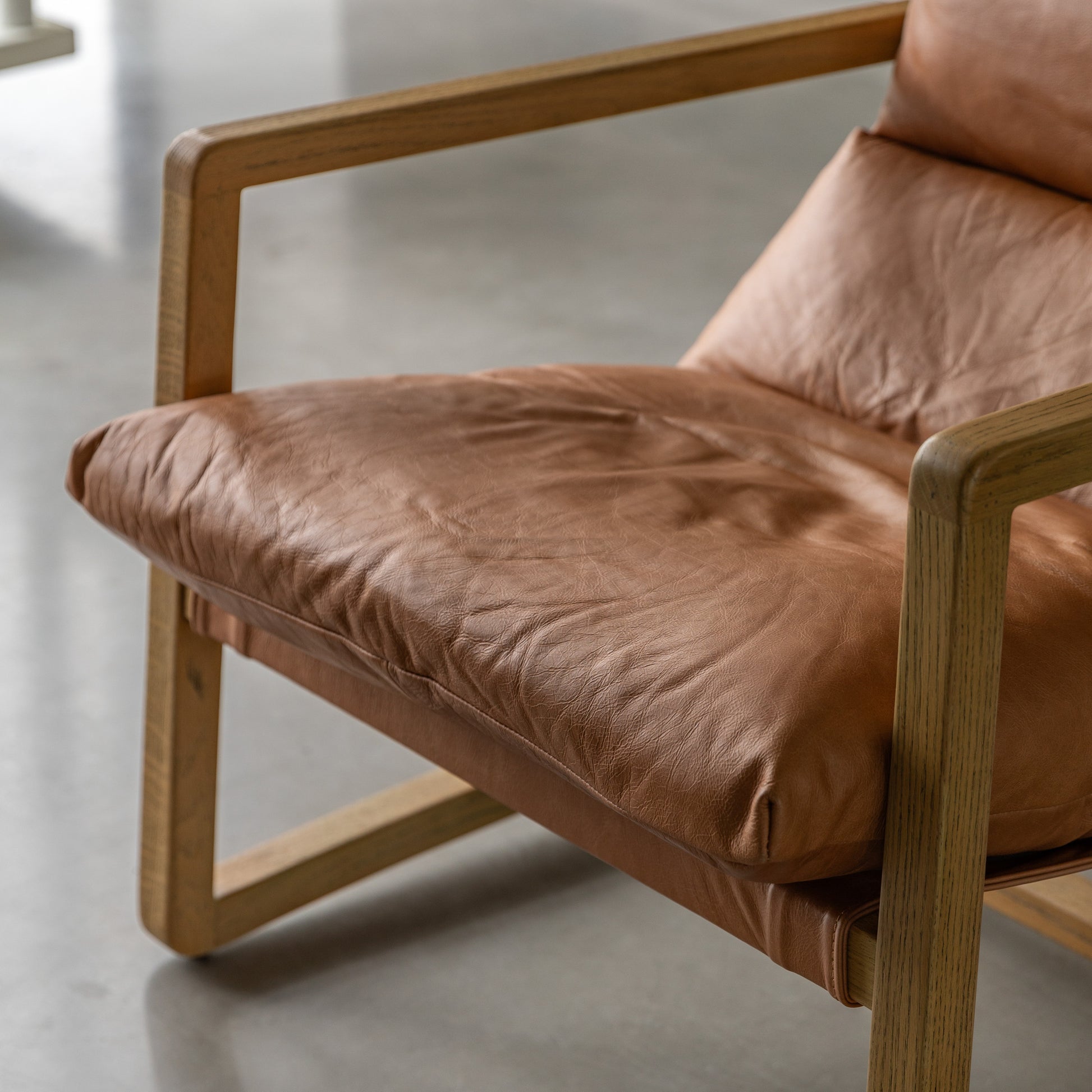 Gallery Direct Burela Lounge Chair in Vintage Brown Leather upholstery with padded seat and back rest for additional comfort, and a sturdy ash wood modern frame