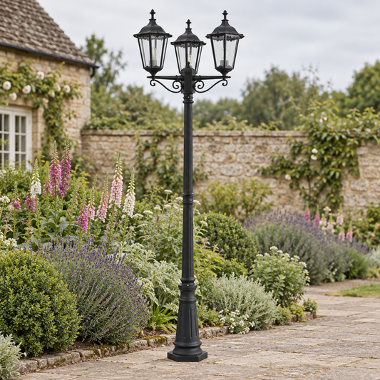 Gallery Direct Burford Outdoor Post Light Three Lanterns installed beside a stone garden path