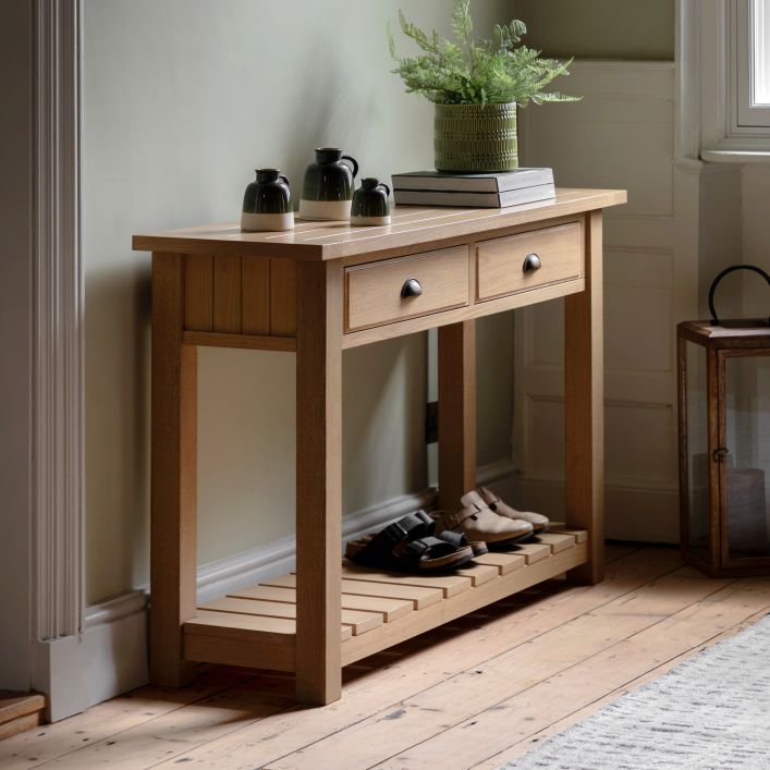 Gallery Direct Eton 2 Drawer Console Table in a Natural Oak effect wooden frame with metal handles and a planked lower shelf 