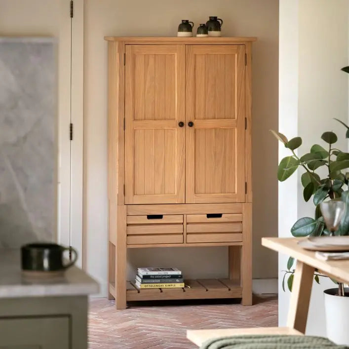 Gallery Direct Eton Larder Cupboard in a Natural Oak wood finish with grooved panel doors, two spacious drawers and a lower planked shelf