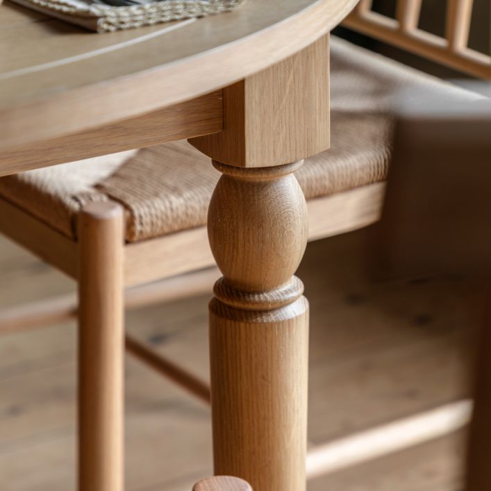 Gallery Direct Eton Round Extending Dining Table with a grooved table top an turned wooden legs constructed from Natural Oak wood and veneers