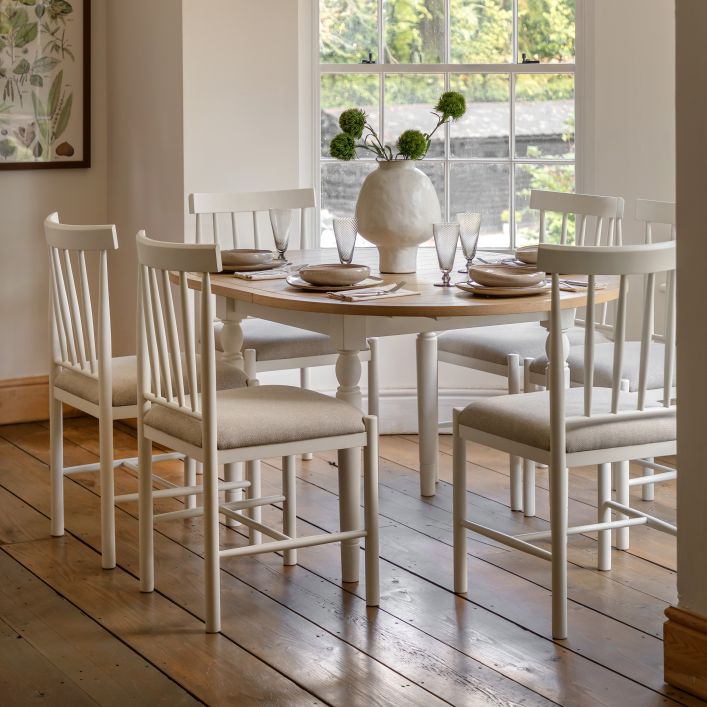 Gallery Direct Eton Round Extending Dining Table with an oak wood and veneer table top that extends to seat 4-6 people, with white turned wood legs