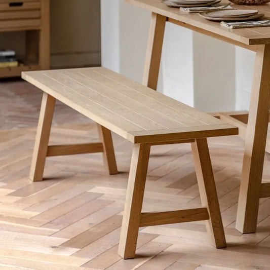 Gallery Direct Eton Trestle Bench in Natural oak wood and veneers with a planked and grooved seat that can accommodate 2-3 people