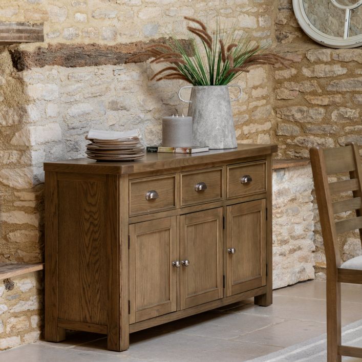 Gallery Direct Hardwick 3 Door 3 Drawer Sideboard is crafted from solid oak and veneers with chic metal handles and internal shelving with the lower cupboards