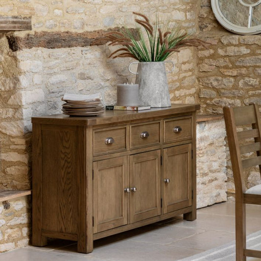 Gallery Direct Hardwick 3 Door 3 Drawer Sideboard is crafted from solid oak and veneers with chic metal handles and internal shelving with the lower cupboards