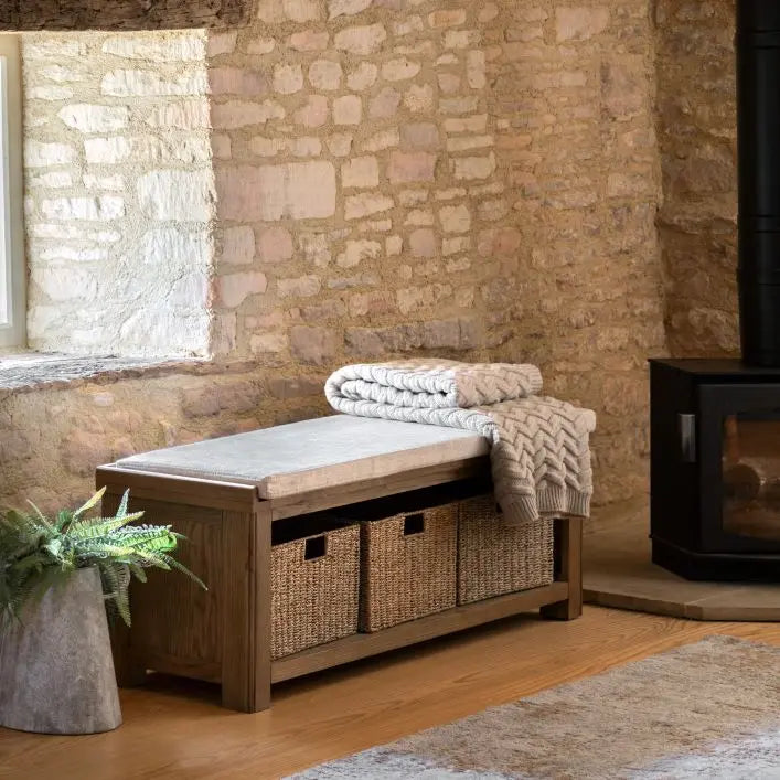 Gallery Direct Hardwick Hall Bench combines practical storage in the form of 3 under seat storage baskets, with the understated elegance of its warm oak wood frame, and comfort of the generously padded seat cushion