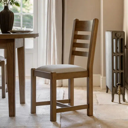 Gallery Direct Hardwick Pair of Dining Chairs with a distinctive slatted back rest design, a neutral padded seat and a robust warm wood finished frame