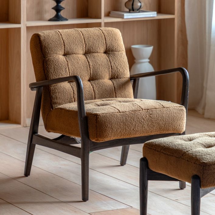 The Gallery Direct Humber Armchair has a dark ash wood frame and padded seat cushion upholstered in Ochre coloured, Faux Sheepskin material