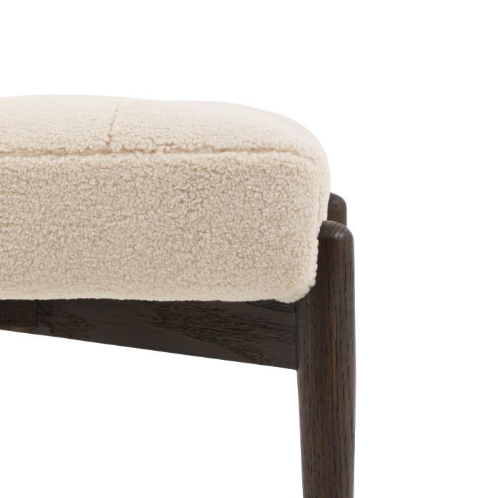 Gallery Direct Humber Footstool upholstered in a Cream coloured Faux Sheepskin fabric with contrasting dark wooden legs