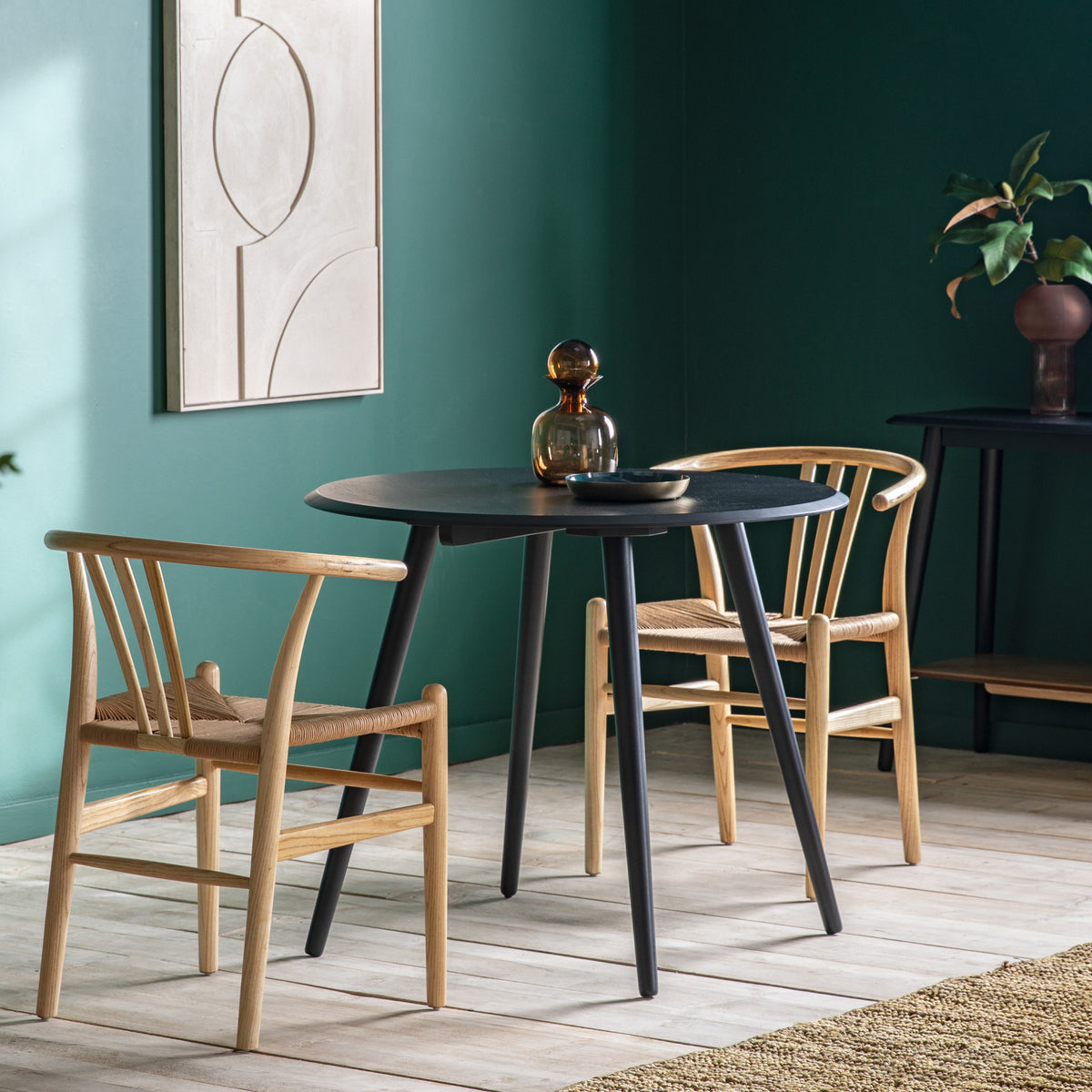 Gallery Direct Maddox Round Dining Table Black styled with chairs in a dining room
