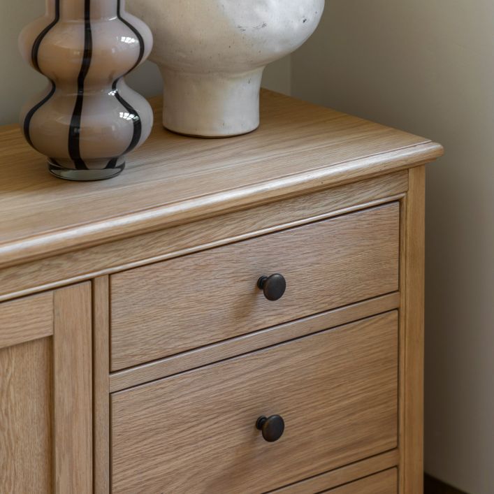 Gallery Direct Malvern 1 Door 4 Drawer Sideboard crafted from warm oak solids and veneers with a wood grain effect, ad round metal handles