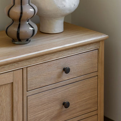Gallery Direct Malvern 1 Door 4 Drawer Sideboard crafted from warm oak solids and veneers with a wood grain effect, ad round metal handles